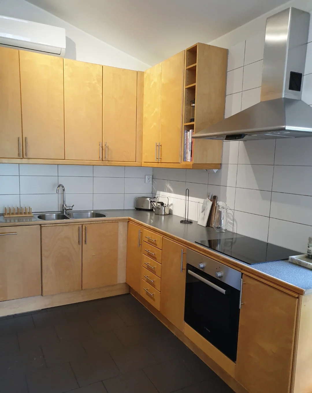 Kök med träskåp, diskho och spis